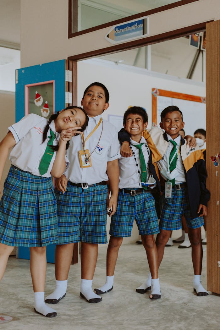 services-03 Happy group of students in school uniforms standing together in a classroom setting.